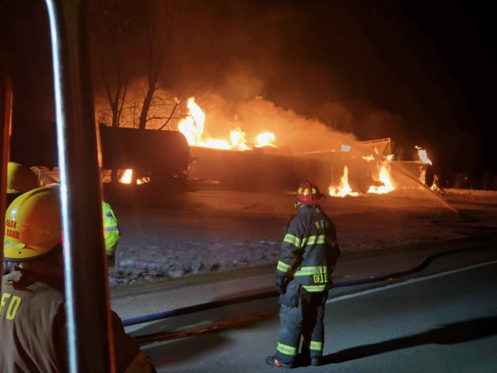 Firefighters look on as flames burst from the derailed train in Raymond, Minnesota.